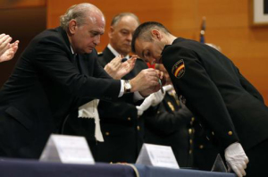 El ministro coloca su condecoración a uno de los agentes homenajeados.