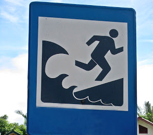 Señal de tráfico que indica hacia dónde correr en caso de tsunami.
