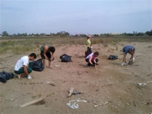 Voluntarios recogen basuras dejadas por la crecida.