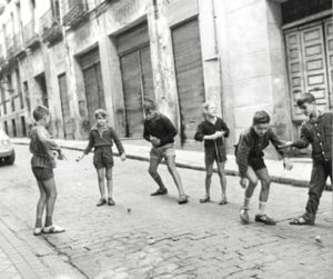 Niño tirando la peonza en las calles de la capital.