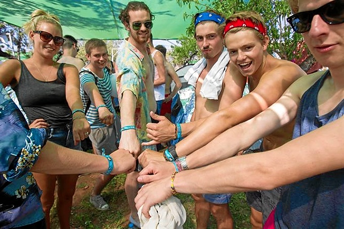 Chicos y chicas enseñan las pulseras del festival